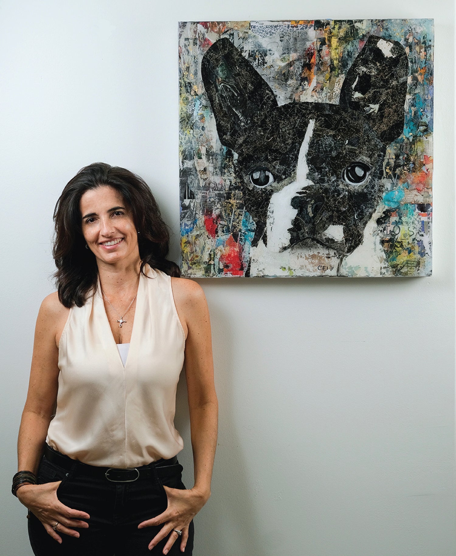 Portrait of mixed media artist M Vigne Arts standing beside Don Juan dog collage artwork