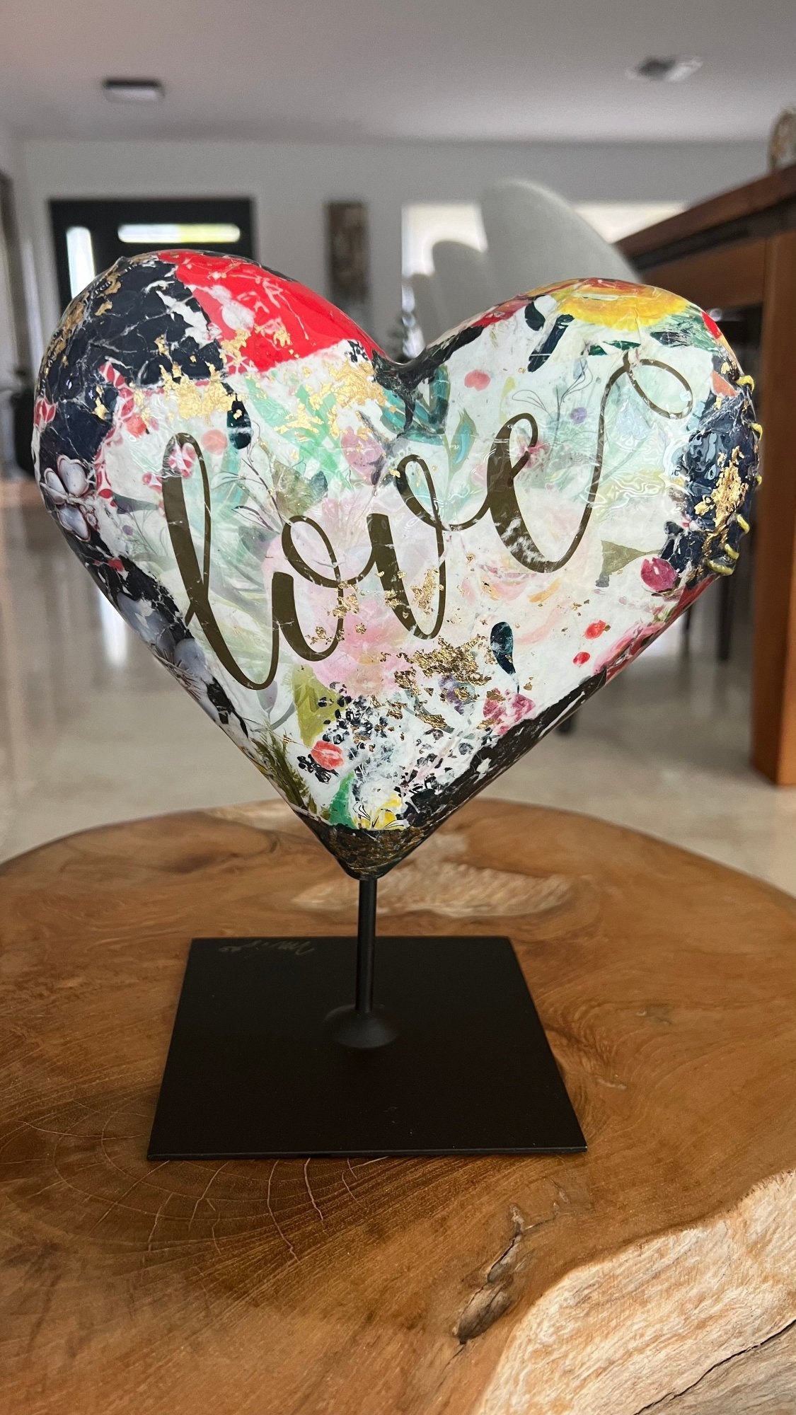 Heart shaped sculpture featuring a portrait and abstract multicolor design